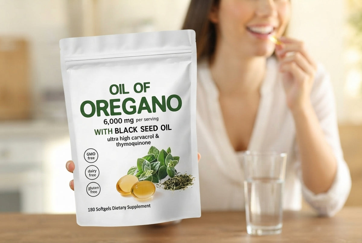 A bottle of oregano oil capsules with fresh oregano and black seeds on a terracotta surface, bathed in bright natural light.